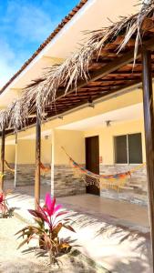 a house with a hammock in front of it at Arena Carneiros Hotel by AFT in Tamandaré