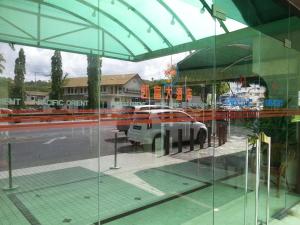 un reflejo de un coche aparcado en un aparcamiento en Pacific Orient Hotel ( 凯富大酒店 ), en Miri