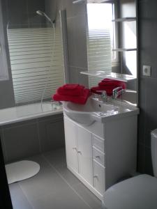 a bathroom with a sink and a tub and a mirror at La Croix du Sud in Le Touquet-Paris-Plage