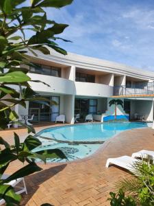 a house with a swimming pool in front of it at Breakers Motel in Whangamata