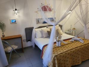 een slaapkamer met een bed met twee knuffels erop bij El Quinto Sol B&B in Copertino