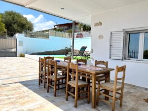 a dining room with a table and chairs on a patio at Sea view 4 bedrooms, 3 bathrooms Cottage in Anavyssos