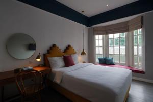 een slaapkamer met een groot bed en een spiegel bij THE FOLK in Kejayan
