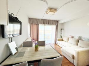 a living room with a table and a couch at Napa Blue Apartment, XXL Pool,in Hearth of Ayia Napa in Ayia Napa