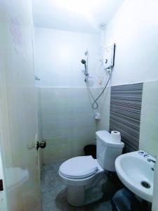 een badkamer met een toilet en een wastafel bij 2020 Travelers Inn in Dumaguete