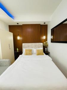 een slaapkamer met een groot wit bed met gele kussens bij Lou- Mesaverte Residences in Cagayan de Oro