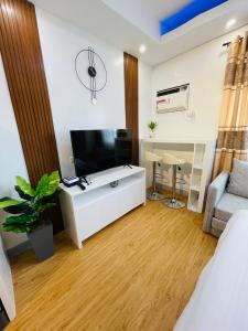 een woonkamer met een televisie en een witte kast bij Lou- Mesaverte Residences in Cagayan de Oro