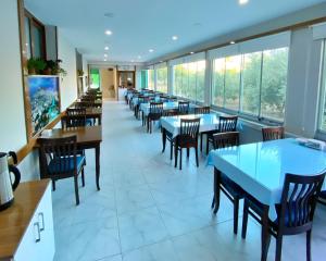 a dining room with tables and chairs and windows at İskele Otel in Tasucu