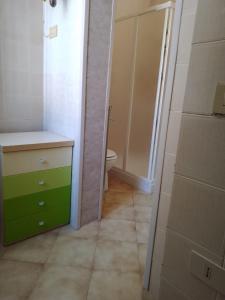 a bathroom with a green cabinet and a toilet at Palazzo tre palme in Follonica