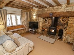 a living room with a couch and a fireplace at Chippy Cottage in Chipping Norton