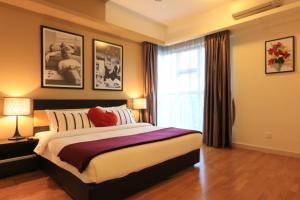 sypialnia z dużym łóżkiem i oknem w obiekcie Suasana Bukit Ceylon Residence w Kuala Lumpur