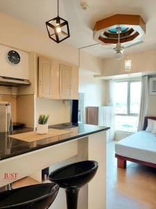 a kitchen with a counter and two stools in a room at King Size Bed At the Heart Of the City in Cagayan de Oro