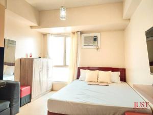 a bedroom with a bed in a room with a window at King Size Bed At the Heart Of the City in Cagayan de Oro