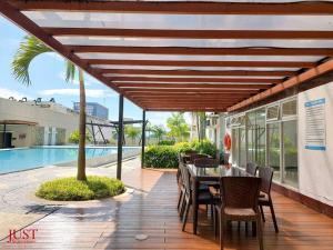 a patio with a table and chairs and a pool at King Size Bed At the Heart Of the City in Cagayan de Oro