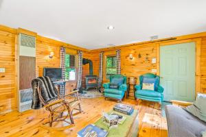 salon z 2 krzesłami i telewizorem w obiekcie Brook Sound Cabin w mieście Schroon Lake