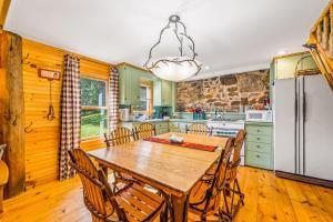 cocina con mesa de madera, sillas y nevera en Brook Sound Cabin, en Schroon Lake