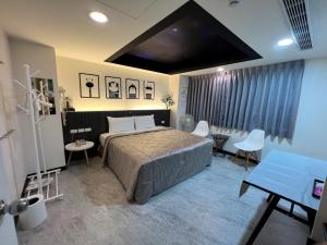 a bedroom with a bed and a table and chairs at Joy Garden Hotel in Kaohsiung