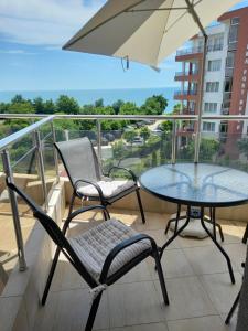 a balcony with a table and chairs and an umbrella at Salvia in Ravda