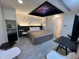 a bedroom with a bed and a tv in a room at Joy Garden Hotel in Kaohsiung