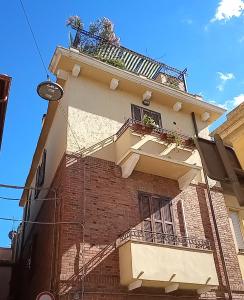 un edificio de ladrillo con un balcón en el lateral. en da nico en Orbetello