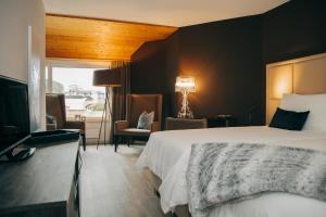 a hotel room with a large bed and a television at Hotel Dakota in Meiringen