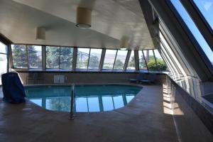 a large swimming pool in a building with windows at Cedars Inn in Wenatchee