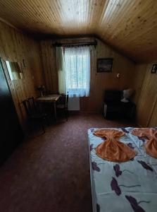 ein Schlafzimmer mit einem Bett und einem Schreibtisch in einem Zimmer in der Unterkunft Garden Etterem Kávézó és Panzió Tahitótfalú in Tahitótfalu