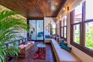 ein Wohnzimmer mit einem langen Sofa und Fenstern in der Unterkunft Nills Suite in Antalya