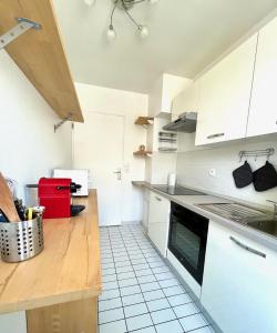 een keuken met witte kasten en een aanrecht bij Capucins - Très bel appartement hyper centre in Reims