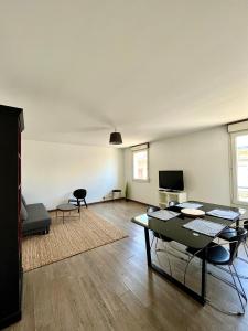 een woonkamer met een tafel en stoelen bij Capucins - Très bel appartement hyper centre in Reims