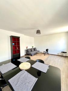 een woonkamer met een bank en een tafel en stoelen bij Capucins - Très bel appartement hyper centre in Reims