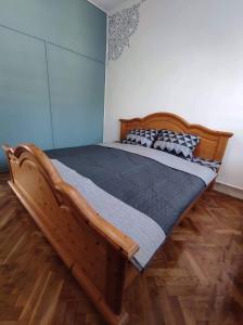 ein Holzbett in einem Schlafzimmer mit Holzboden in der Unterkunft BB Apartman Hajdúnánás in Hajdúnánás