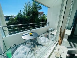 een balkon met een tafel en stoelen bij Apartment Sünnanbeter mit Pool für 2-4 Personen in Dahme