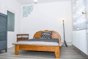 ein Schlafzimmer mit einem Holzbett in einem Zimmer in der Unterkunft BB Apartman Hajdúnánás in Hajdúnánás