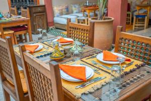 a table with orange napkins and plates on it at Riad Euphorbe in Marrakesh