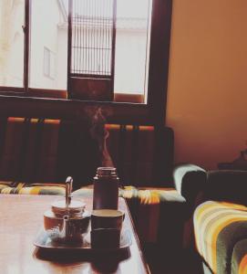 bandeja de tazas de café en una mesa en una habitación en ゲストハウス　華屋 (guest house HANAYA）, en Sado