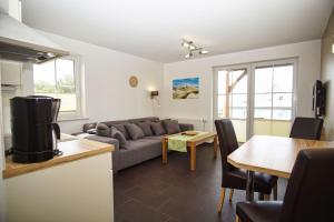 ein Wohnzimmer mit einer Couch und einem Tisch in der Unterkunft Schicke FeWo mit Terrasse, gratis Nutzung vom AHOI Erlebnisbad und Sauna in Sellin - Haus De niege Wech FeWo 01 in Thiessow