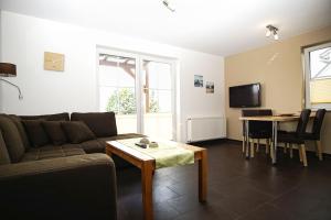 a living room with a couch and a table at Schicke FeWo mit Terrasse, gratis Nutzung vom AHOI Erlebnisbad und Sauna in Sellin - Haus De niege Wech FeWo 02 in Thiessow