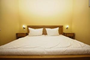 ein Bett mit weißen Laken und Kissen in einem Zimmer in der Unterkunft Schicke FeWo mit Terrasse, gratis Nutzung vom AHOI Erlebnisbad und Sauna in Sellin - Haus De niege Wech FeWo 01 in Thiessow + 20 Fotos