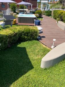 un jardín con banco y piscina en Hotel Malavoglia en Acitrezza