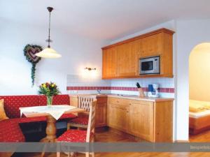 una pequeña cocina con mesa y microondas en Apartment at the Achensee with balcony or terrace, en Lago Achen