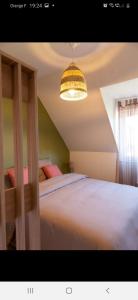 sypialnia z dużym białym łóżkiem i żyrandolem w obiekcie A stondeta w Beauvais