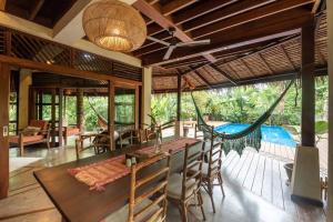 uma sala de jantar com uma rede de descanso e uma piscina em Alaia Hideaway em General Luna