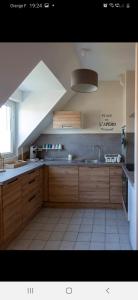 uma grande cozinha com armários de madeira e um lavatório em A stondeta em Beauvais
