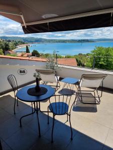 a balcony with tables and chairs and a view of the water at N&N Apartments and Rooms by Locap Group in Portorož