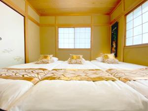 a group of three beds in a room with windows at YOUAN - Vacation STAY 36473v in Oishi