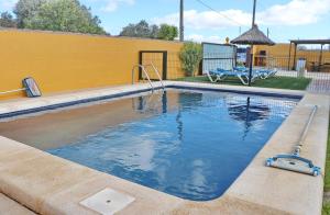 a swimming pool in a yard with a yellow wall at Casa Calas Boliña in Roche
