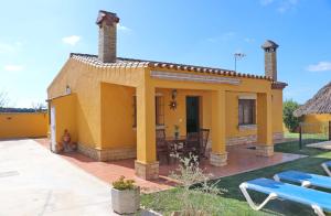 a small yellow house with a table and chairs at Casa Calas Boliña in Roche +19 photos