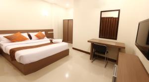 Un dormitorio con una cama, un escritorio y un televisor. en JJ Villa, en Khon Kaen