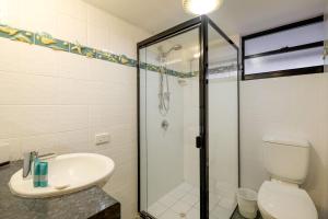 uma casa de banho com um chuveiro, um lavatório e um WC. em Mooloomba Two em Point Lookout